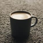 cup of coffee on brown carpet